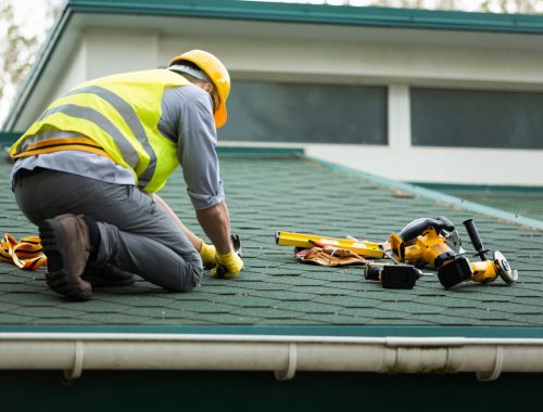 Roofer working in protective work wear gloves,